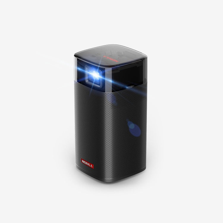 A Nebula Apollo portable projector sits in a white room while displaying a blue light off screen.
