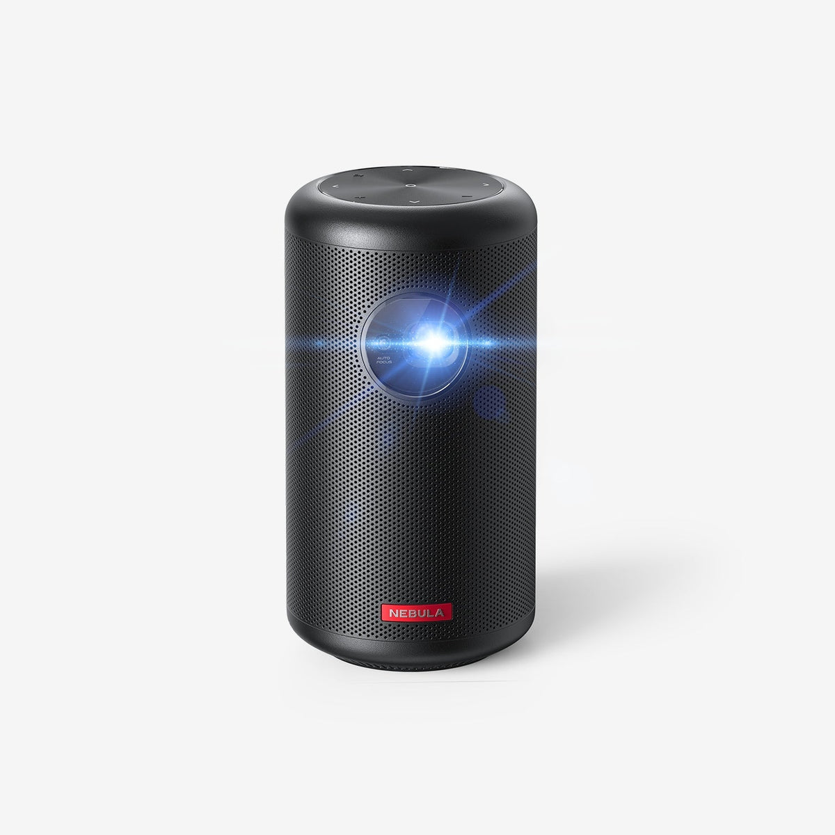 A Nebula Capsule Max portable projector sits in a white room projecting a blue light toward the camera.